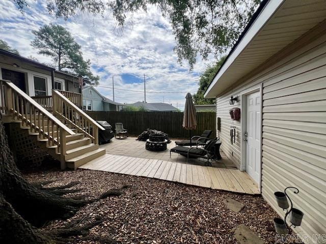 exterior space featuring a fire pit, stairs, fence, and a deck