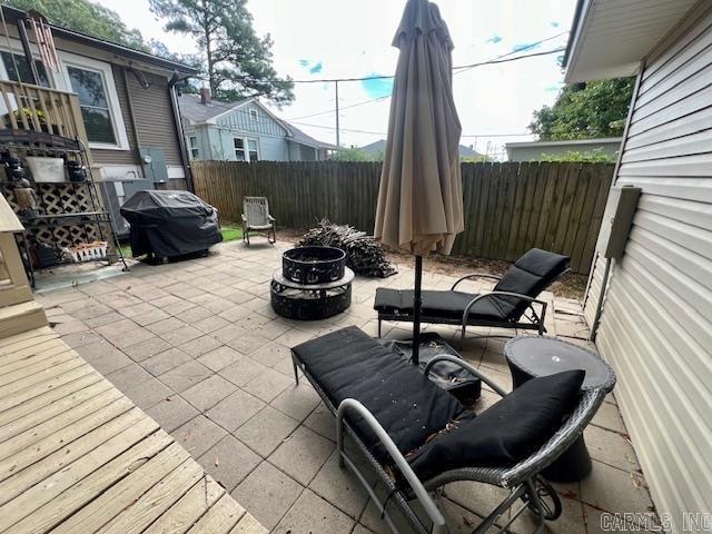 view of patio featuring a fenced backyard, a grill, and a fire pit