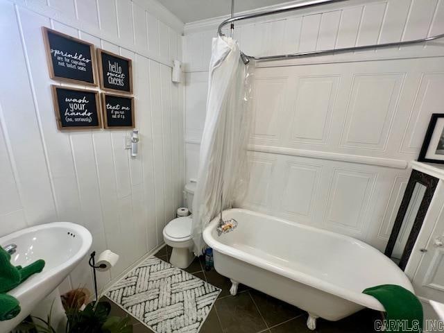 full bath with shower / bath combo with shower curtain, toilet, and tile patterned floors