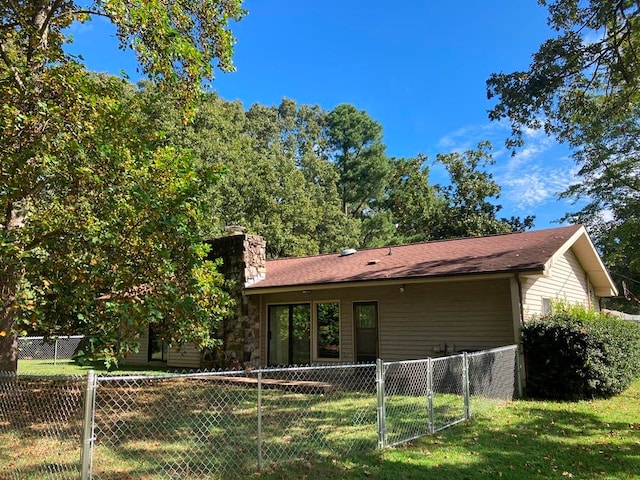 rear view of house featuring a lawn