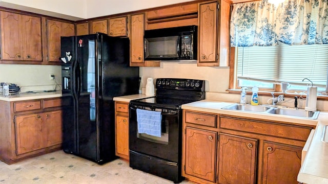 kitchen with black appliances, light countertops, brown cabinets, and a sink