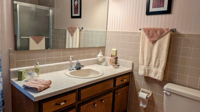 bathroom with vanity, toilet, an enclosed shower, and tasteful backsplash