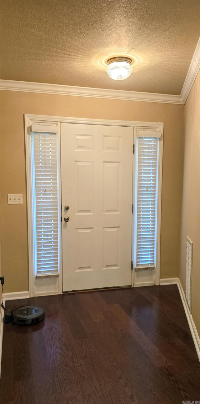 foyer entrance with dark hardwood / wood-style floors, crown molding, and a textured ceiling