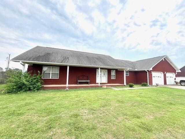 single story home with a garage and a front yard