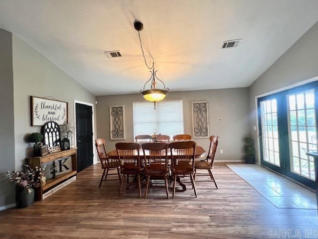 dining space featuring lofted ceiling, plenty of natural light, and wood-type flooring