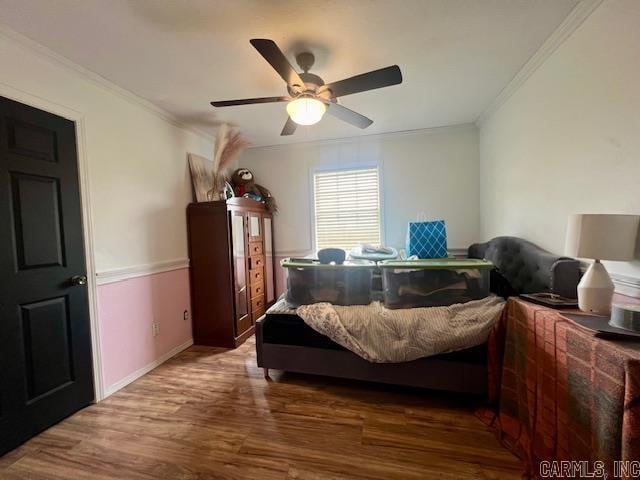 bedroom with dark wood-type flooring, ceiling fan, and ornamental molding