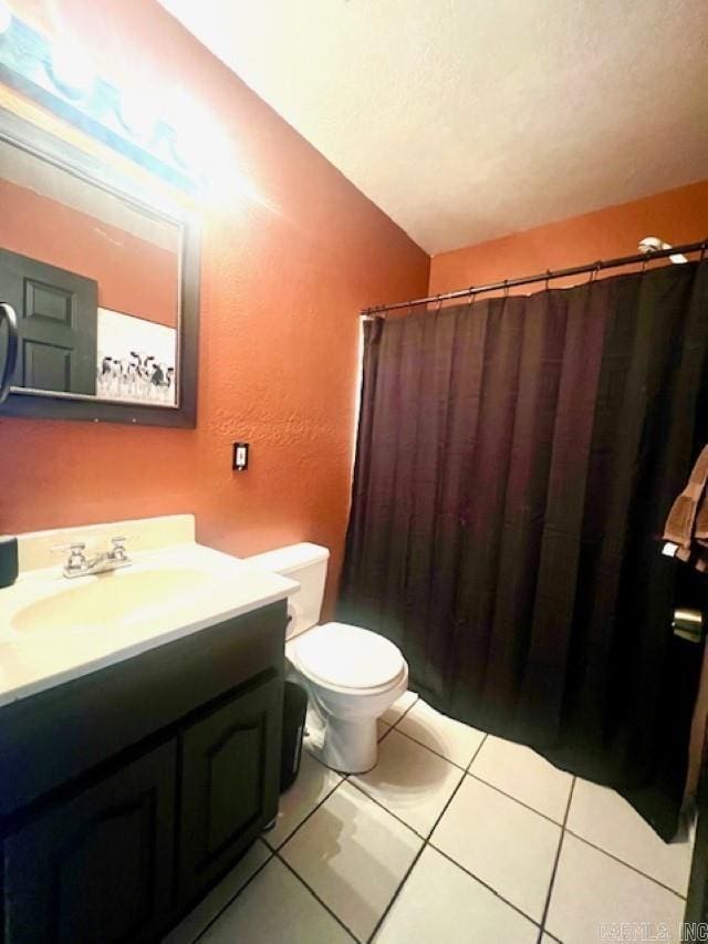 bathroom featuring tile patterned flooring, toilet, a textured ceiling, and vanity