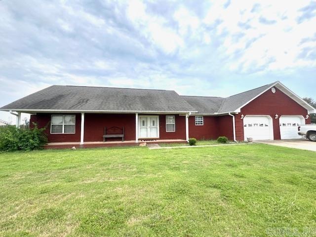 ranch-style house with a garage and a front lawn