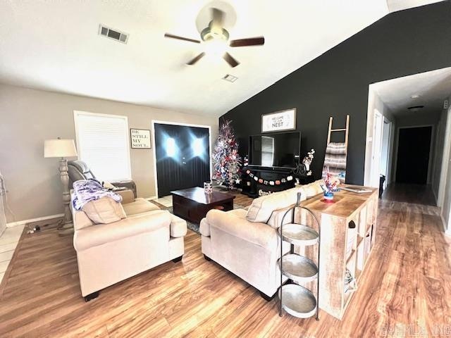 living room with lofted ceiling, ceiling fan, and light hardwood / wood-style floors