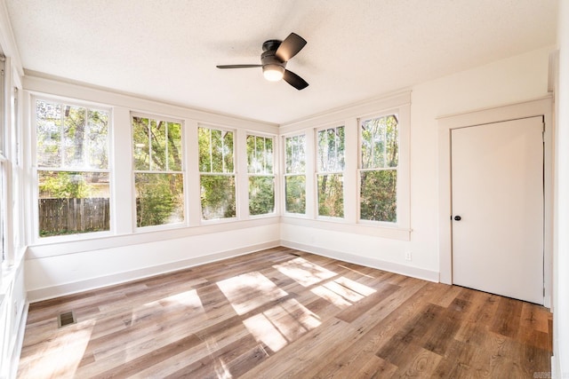 unfurnished sunroom with ceiling fan