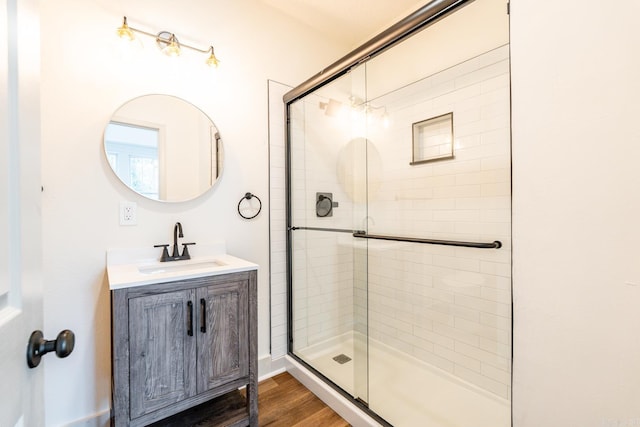 bathroom with an enclosed shower, hardwood / wood-style flooring, and vanity