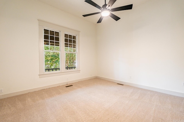 empty room with ceiling fan and light carpet