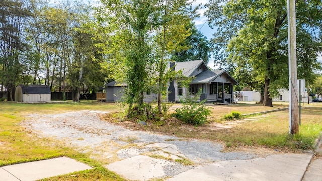 view of front of house with a porch and a shed