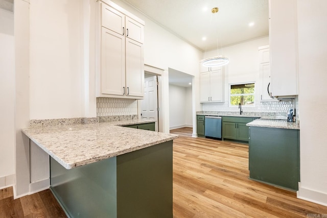 kitchen featuring pendant lighting, stainless steel dishwasher, white cabinets, and light hardwood / wood-style floors