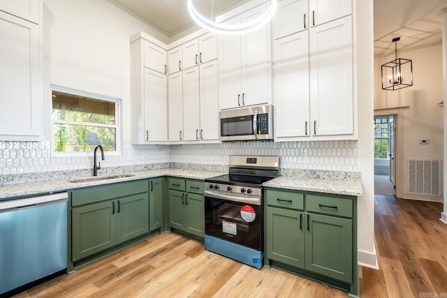 kitchen featuring stainless steel appliances, sink, light wood-type flooring, and green cabinets