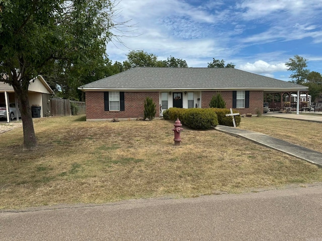 single story home with brick siding, a shingled roof, a front yard, and fence