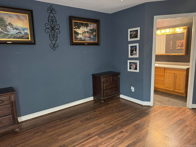 bedroom with dark wood-type flooring and ensuite bath