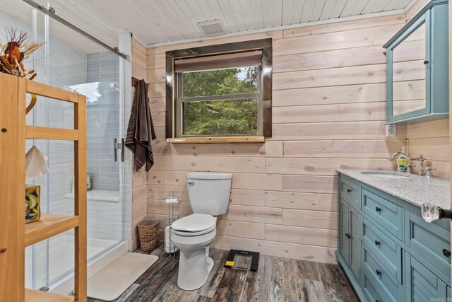 bathroom with hardwood / wood-style flooring, walk in shower, toilet, wood walls, and vanity