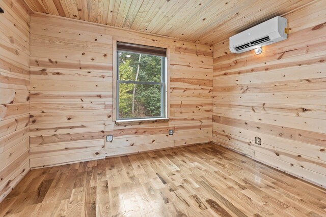 interior space with wood ceiling, wooden walls, an AC wall unit, and light hardwood / wood-style flooring