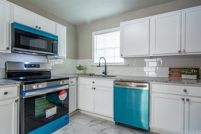 kitchen featuring appliances with stainless steel finishes, sink, and white cabinets