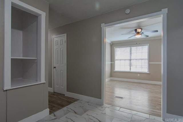 spare room with light wood-type flooring, ceiling fan, and crown molding