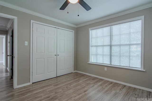 unfurnished bedroom featuring a closet, ceiling fan, light hardwood / wood-style floors, and crown molding