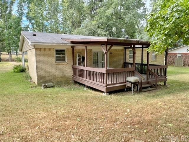 rear view of house featuring a yard and a wooden deck