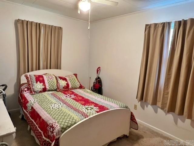 carpeted bedroom with ceiling fan and ornamental molding