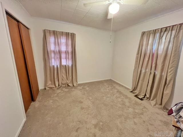 unfurnished bedroom with a closet, ceiling fan, and light colored carpet