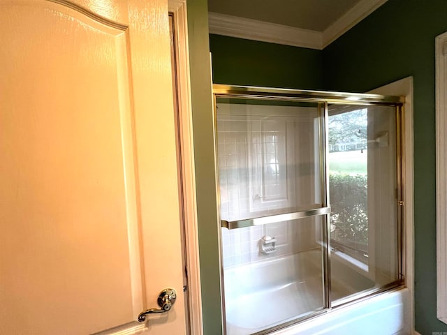 bathroom featuring ornamental molding and shower / bath combination with glass door