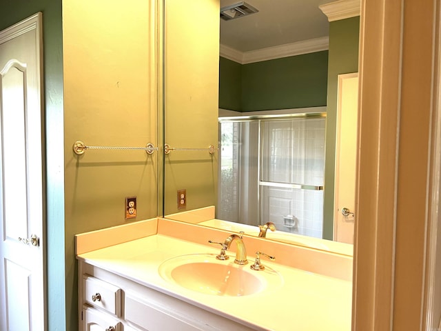 bathroom with vanity, crown molding, visible vents, and walk in shower