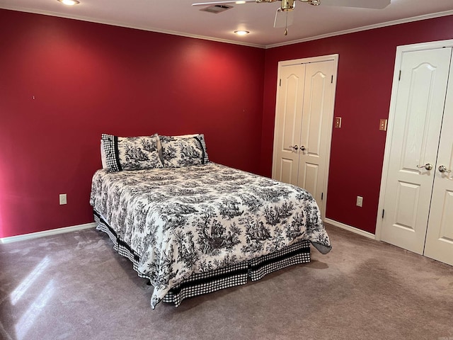 bedroom featuring visible vents, crown molding, baseboards, carpet flooring, and a ceiling fan