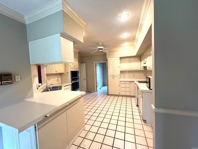 kitchen featuring ceiling fan, sink, ornamental molding, a textured ceiling, and white cabinetry