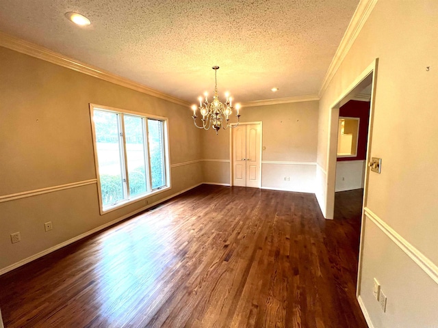 unfurnished room with a textured ceiling, crown molding, dark hardwood / wood-style flooring, and a chandelier