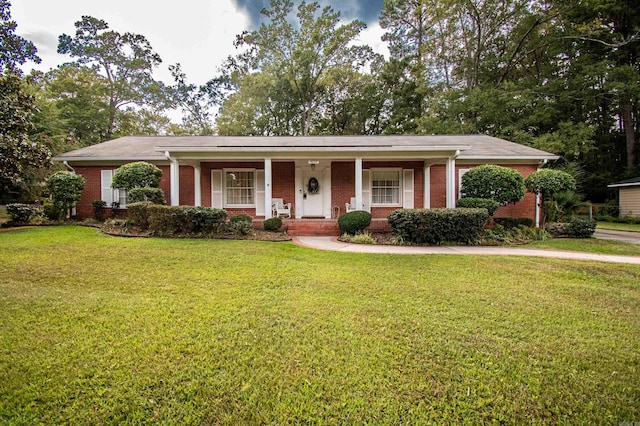 ranch-style house with a front yard, covered porch, and brick siding