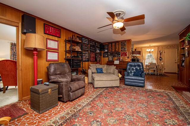 living room featuring ceiling fan and wood walls