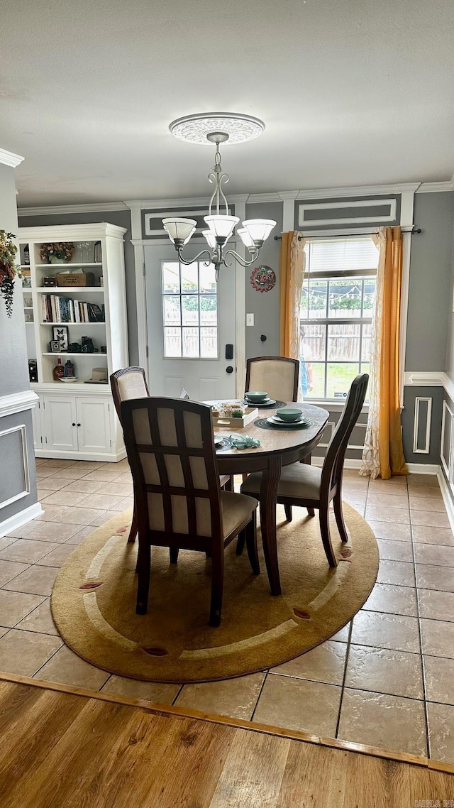 dining area featuring light wood-type flooring, crown molding, and an inviting chandelier