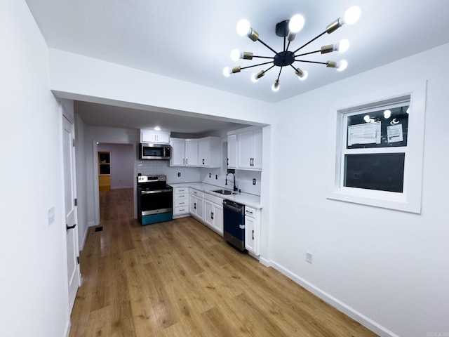 kitchen featuring white cabinets, light hardwood / wood-style flooring, appliances with stainless steel finishes, sink, and decorative backsplash