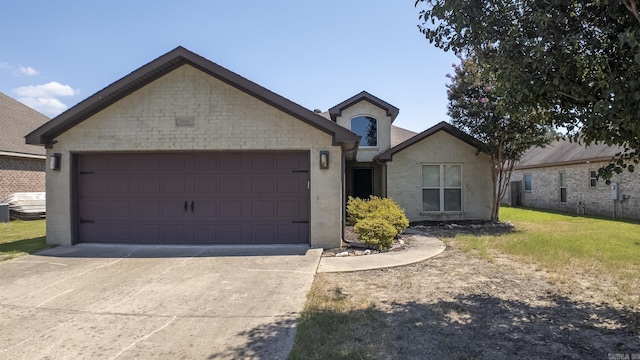 view of front of home featuring a garage, brick siding, driveway, and a front lawn