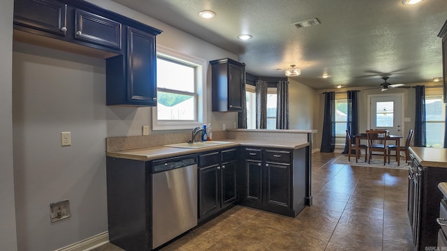 kitchen with visible vents, light countertops, stainless steel dishwasher, a sink, and a peninsula