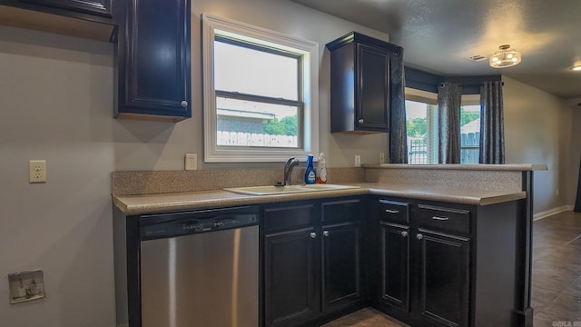 kitchen with a peninsula, a sink, visible vents, baseboards, and stainless steel dishwasher