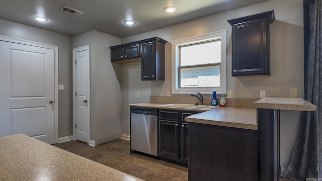 kitchen featuring dishwasher, light countertops, a sink, and visible vents