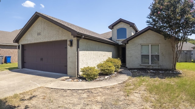 view of front of property with a garage, concrete driveway, and a shingled roof