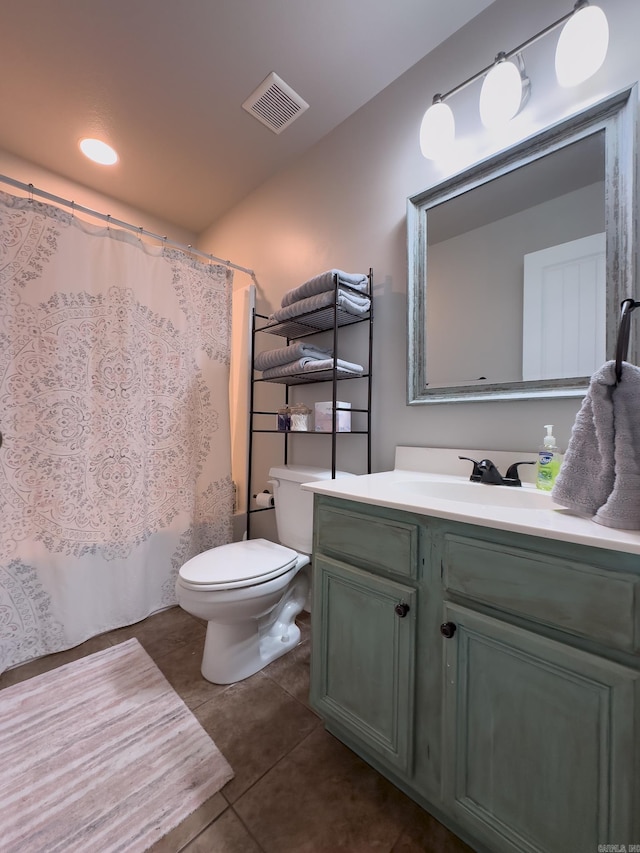 full bathroom featuring toilet, vanity, visible vents, and tile patterned floors