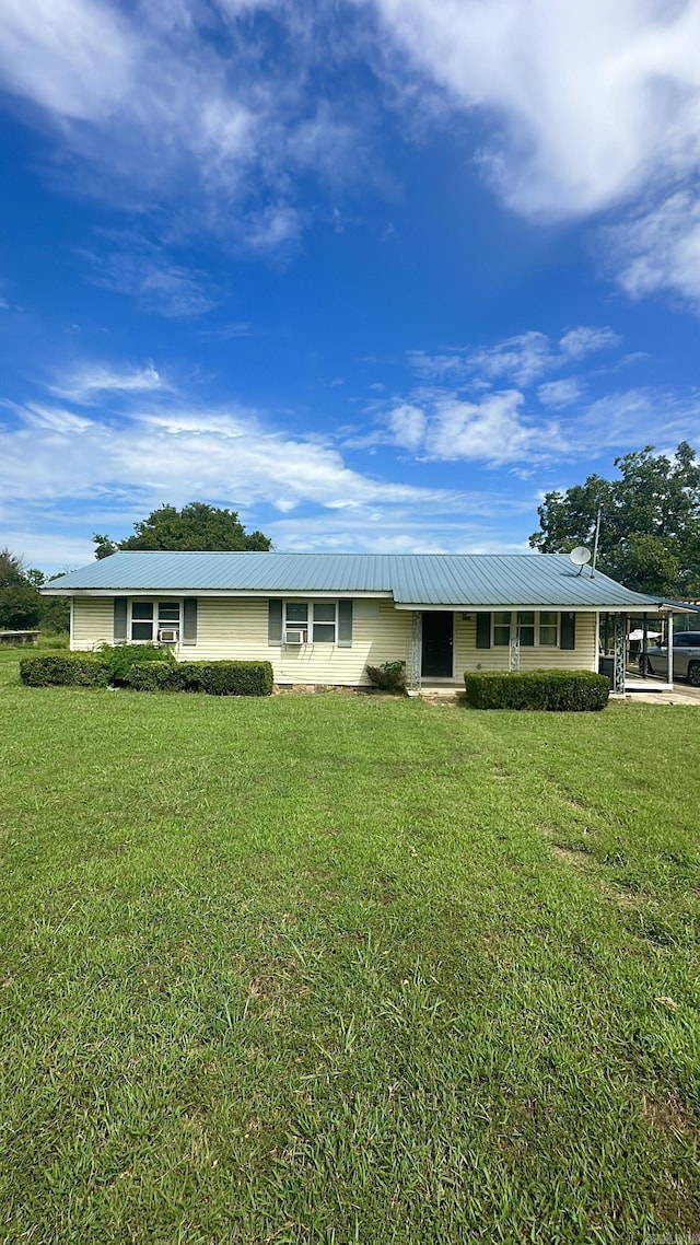 ranch-style house featuring metal roof and a front yard