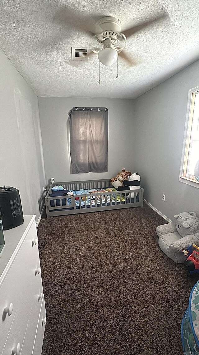 hall featuring carpet flooring and a textured ceiling