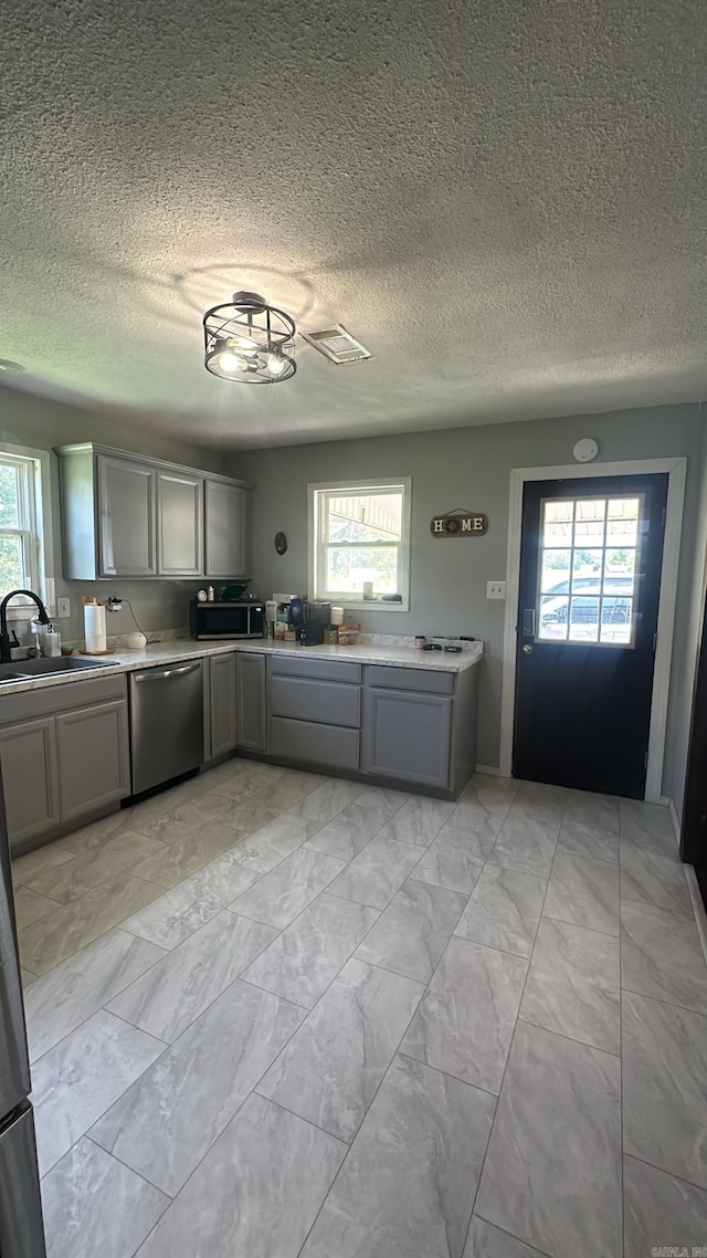 kitchen with stainless steel dishwasher, plenty of natural light, and sink