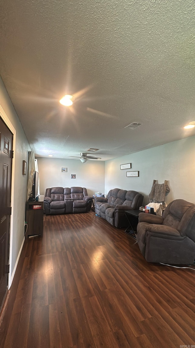 living room with dark wood-type flooring and a textured ceiling