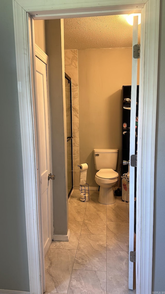 bathroom featuring toilet and a textured ceiling