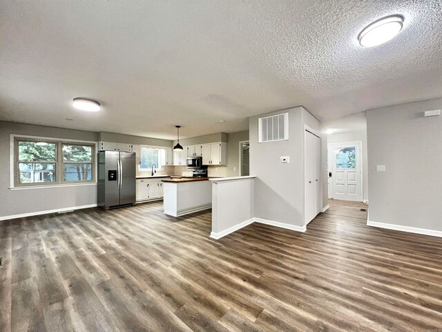 kitchen featuring plenty of natural light, stainless steel appliances, hardwood / wood-style floors, and white cabinetry